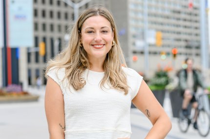 Blonde woman standing in front of two buildings