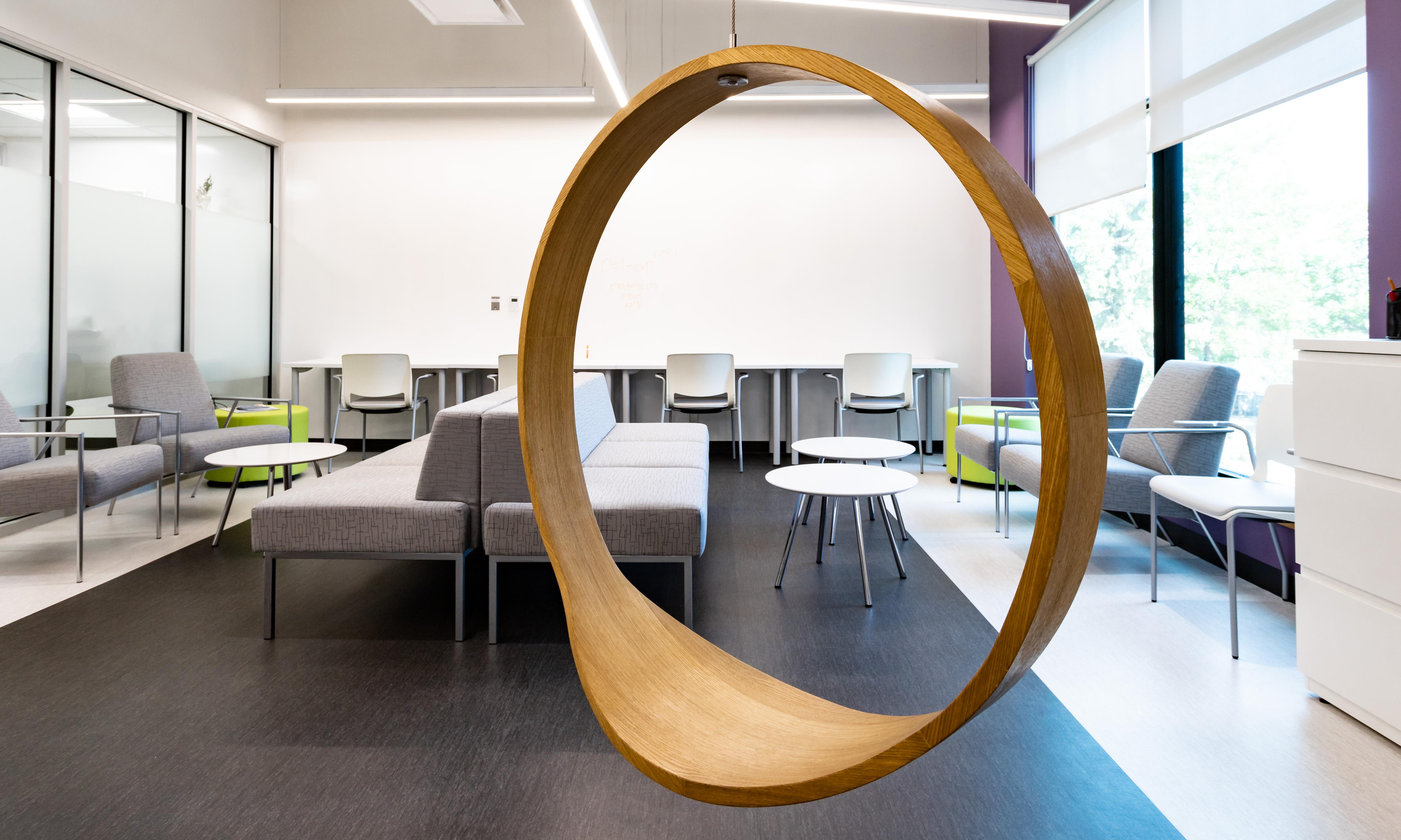 Seven Oaks General Hospital, Chronic Disease Innovation Centre. Modern office lounge with a round swing in the foreground. 